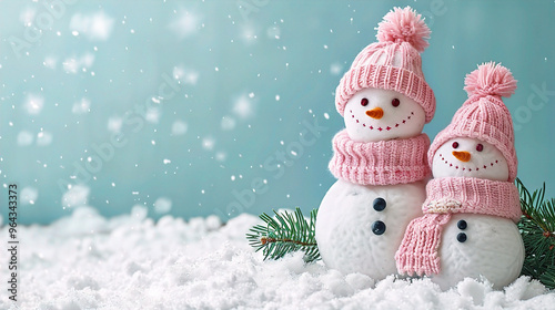 Knitted snowmen on soft snowy winter copy space Christmas background

