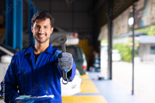 Portrait hispanic latin male mechanic repairs car in garage. Auto car mechanic professional working and checking car engine at garage. Car repair and maintenance