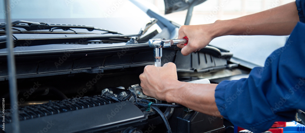 Professional mechanic working on the engine , repairing a car engine automotive workshop with a wrench, car service and maintenance,Repair service. Professional mechanic working on the engine , repairing a car engine automotive workshop with a wrench, car service and maintenance,Repair service.