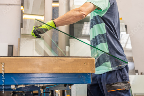 A glazier places sheets of glass on a specialized table. The concept of craftsmanship and industry. Working with glass.. photo