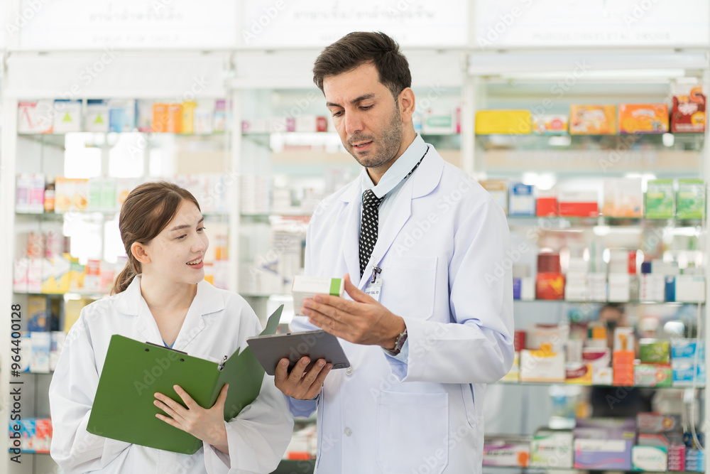 Pharmacist male and woman in white uniform inspecting list of medicine in drugs shop pharmacy