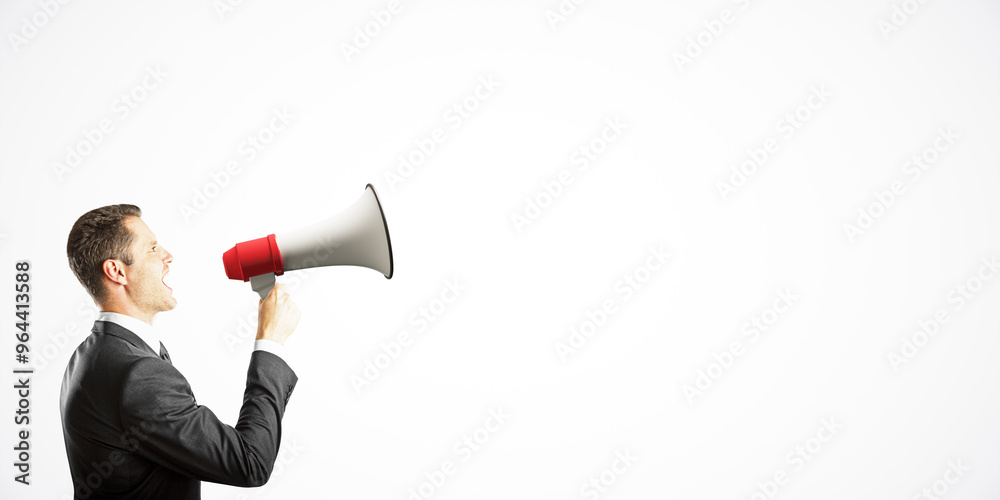Businessman in a suit shouting into a megaphone on a white background, symbolizing communication and marketing concepts. Businessman in a suit shouting into a megaphone on a white background, symbolizing communication and marketing concepts.
