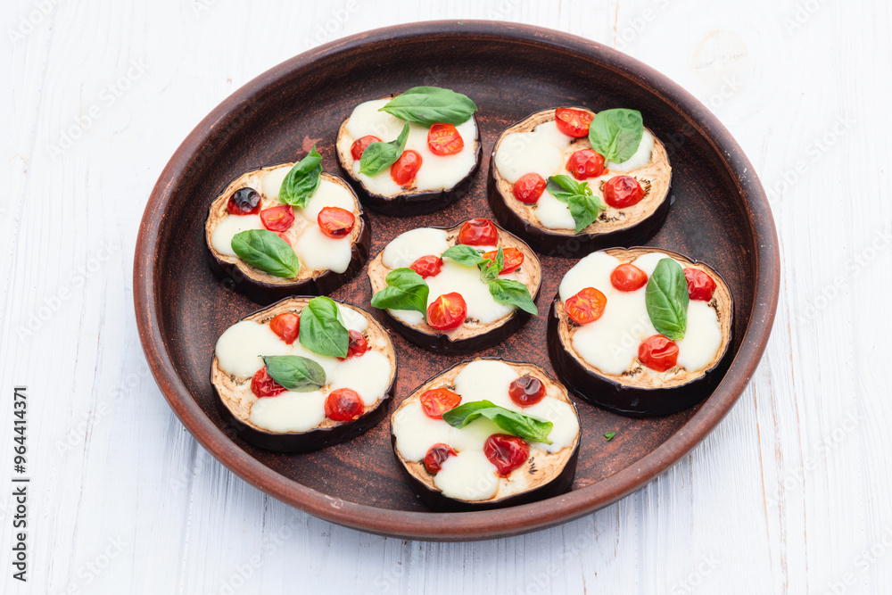 Italian mini pizza . Aubergine (eggplant ) with mozzarella cheese and basil . On rustic background Italian mini pizza . Aubergine (eggplant ) with mozzarella cheese and basil . On rustic background