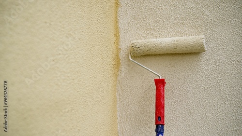 Construction worker painting a wall with a paint roller. photo