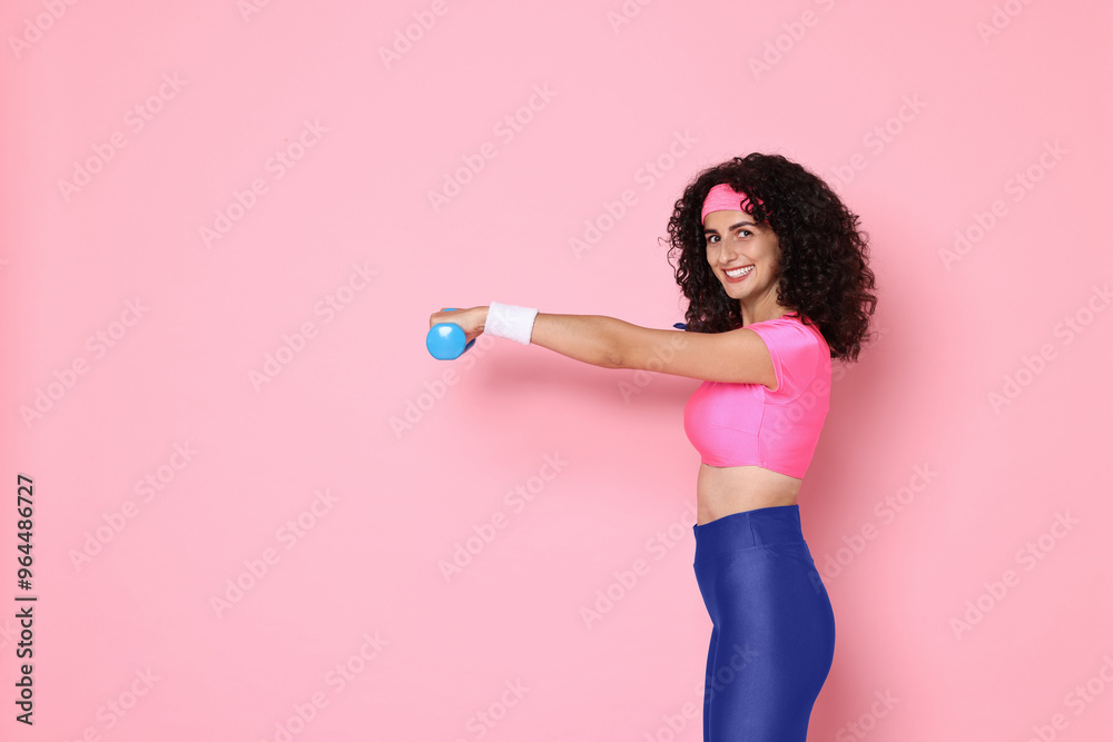 Woman doing aerobic exercise with dumbbells on pink background, space for text