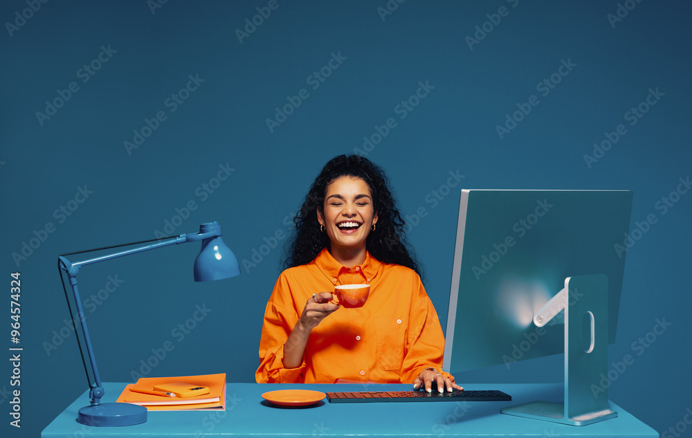 © Jacob Lund - Employee enjoying a coffee break while working at her computer, color blocking studio shot