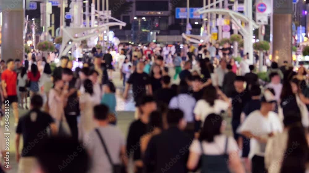 Blurred view along famous pedestrian street Gunam in Haeundae district of Busan, in late evening. Numerous local and foreign tourists stroll along walking street lined with restaurants and cafes.