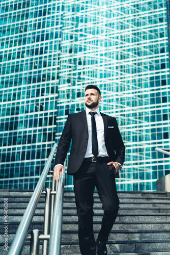 Pensive businessman walking down stairs in city center