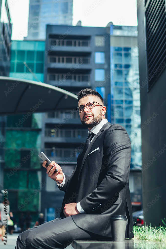 Adult pleased employee with takeaway hot drink making decision while using smartphone in downtown