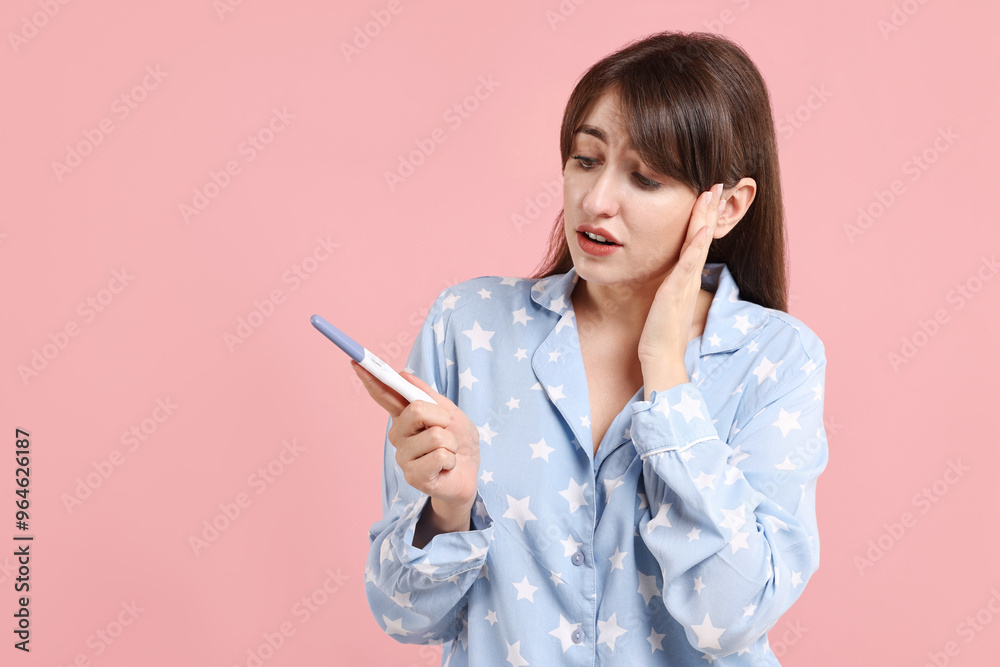 Worried young woman with pregnancy test on pink background, space for text Worried young woman with pregnancy test on pink background, space for text