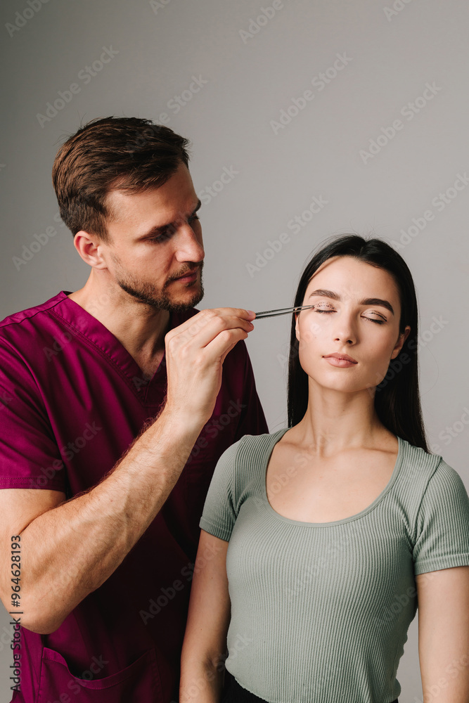 Blepharoplasty. Surgeon is checking distance in between dotted lines on eyelid with anatomical tweezers. Upper blepharoplasty marking eyelid. Blepharoplasty. Surgeon is checking distance in between dotted lines on eyelid with anatomical tweezers. Upper blepharoplasty marking eyelid.
