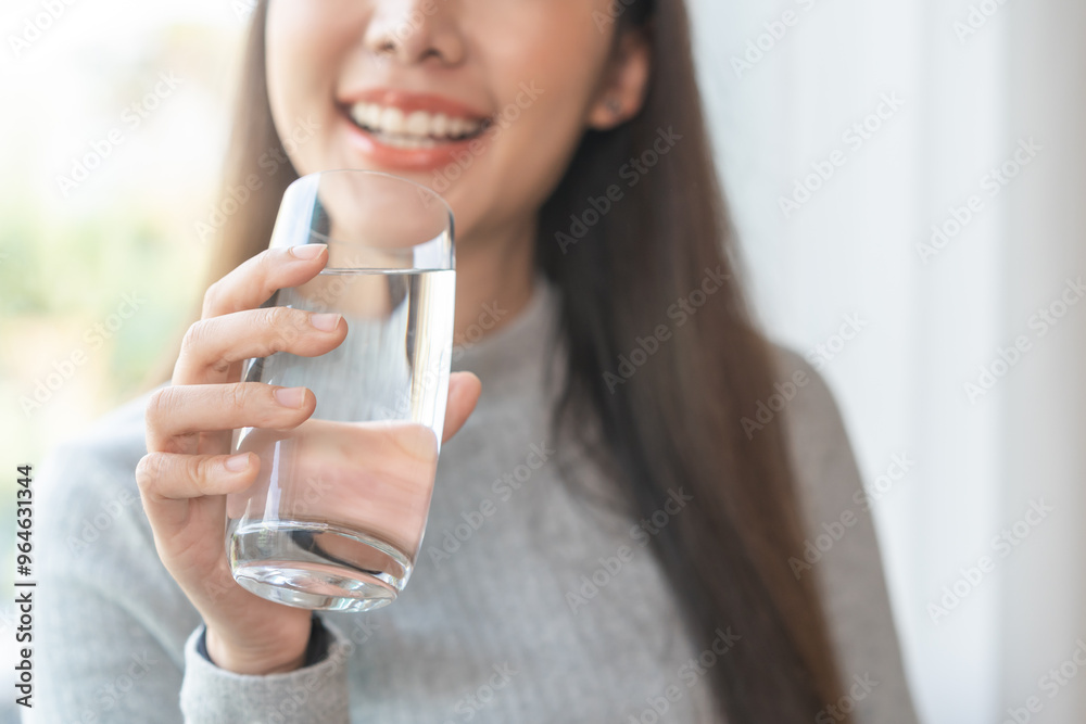 Happy beautiful, asian young woman, girl drinking, sip fresh glass of water for hydration of body, holding transparent glass in her hand, thirsty at home. Health care, healthy lifestyle concept. Happy beautiful, asian young woman, girl drinking, sip fresh glass of water for hydration of body, holding transparent glass in her hand, thirsty at home. Health care, healthy lifestyle concept.