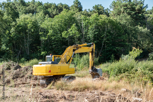 Escavadora de esteiras em ação na escavação de um charco para reservatório de água para a rega agricula photo