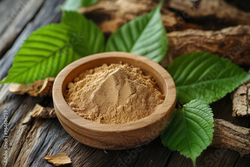 Slippery elm bark powder is being presented in a wooden bowl, surrounded by fresh leaves and pieces of bark