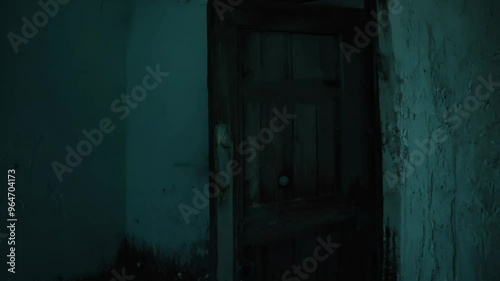 An old, wooden door creaking open slowly in an abandoned house, casting an eerie, unsettling atmosphere. photo