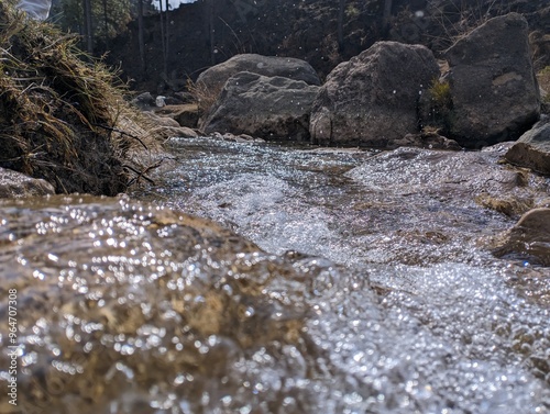 Obraz na plátne stream of river flowing between rocks in a valley
