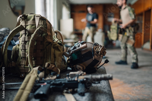 Close up of airsoft gear and equipment with players in background photo