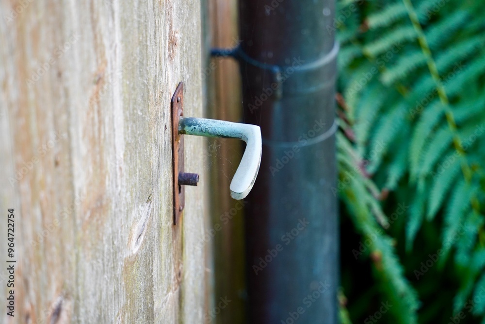 Old rusty white metallic door handle on a wooden door. Old rusty white metallic door handle on a wooden door.
