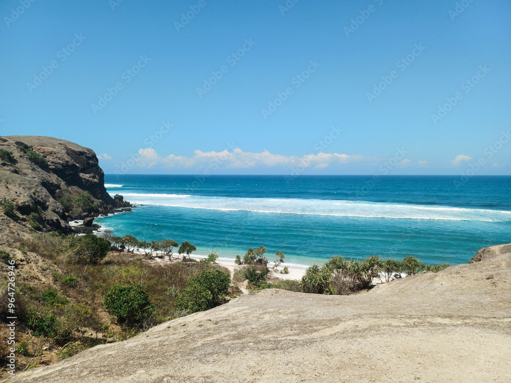 a rock cliff with waves crashing on the shore, Cliff overlooking beach, senggigi beach, Beach in West Nusa Tenggara a rock cliff with waves crashing on the shore, Cliff overlooking beach, senggigi beach, Beach in West Nusa Tenggara