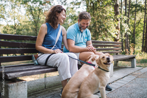 Couple enjoy time together in the park with their dogs