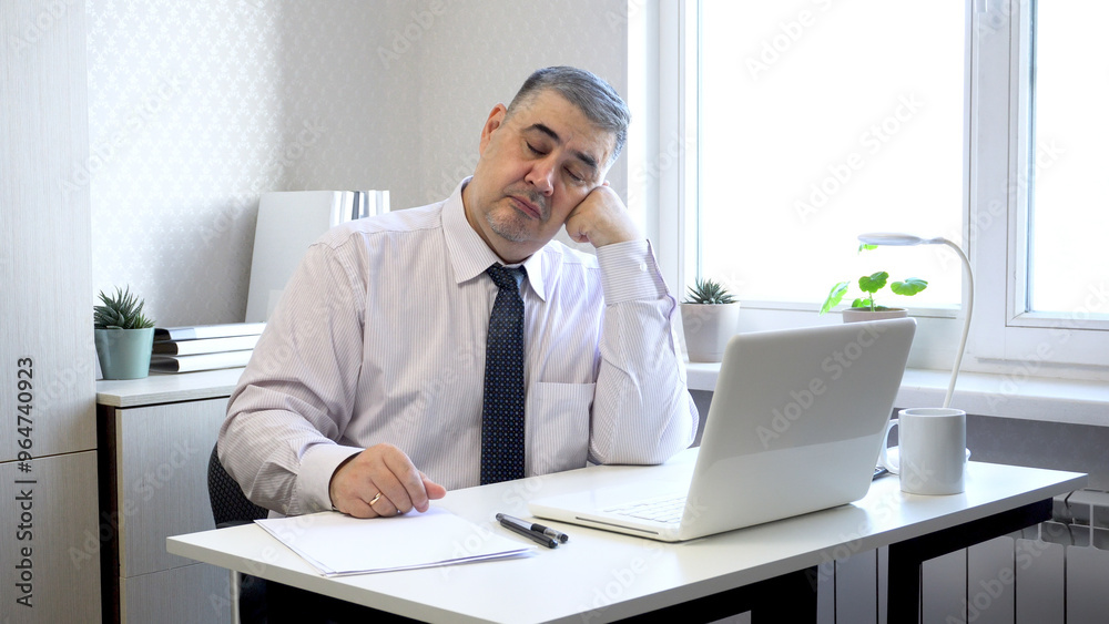 Man Napping at Office Desk with Head Resting on Hand Man Napping at Office Desk with Head Resting on Hand