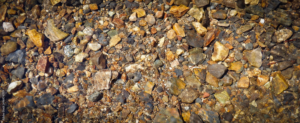 View of shimmering rocks in a stream bed. View of shimmering rocks in a stream bed.