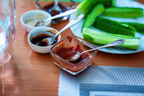 array of sauces nestled in small bowls graces the dining table, inviting a blend of flavors to enhance each dish. These colorful dips celebrate culinary creativity and enhance the meal experience photo