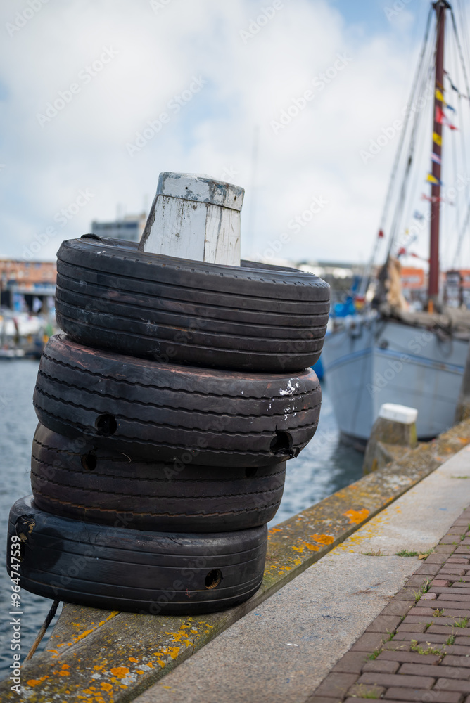 old tyres on a pole in the harbour for mooring boats old tyres on a pole in the harbour for mooring boats