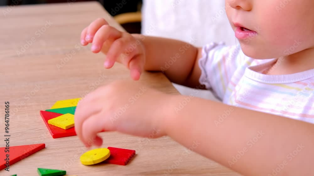 Lovely 3 years toddler, child playing with colored wooden geometric figures at home, in kindergarten, creating patterns, concept of fine motor skills, development creativity, children's entertainment Lovely 3 years toddler, child playing with colored wooden geometric figures at home, in kindergarten, creating patterns, concept of fine motor skills, development creativity, children's entertainment