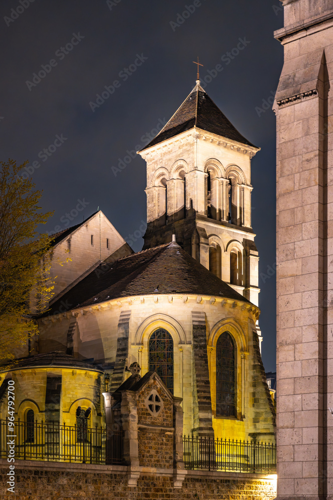 Fototapeta premium The Church of Saint-Pierre de Montmartre is illuminated under the night sky, showcasing its architectural beauty in Paris, France.
