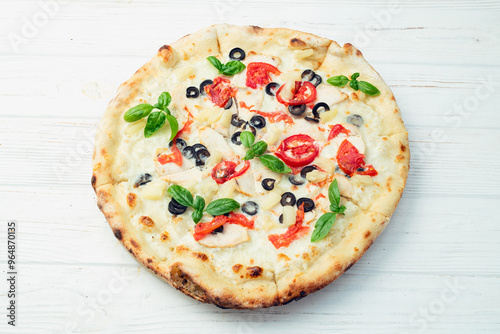 Pizza with mozzarella cheese , olives , chicken , pineapple , basil and tomatoes