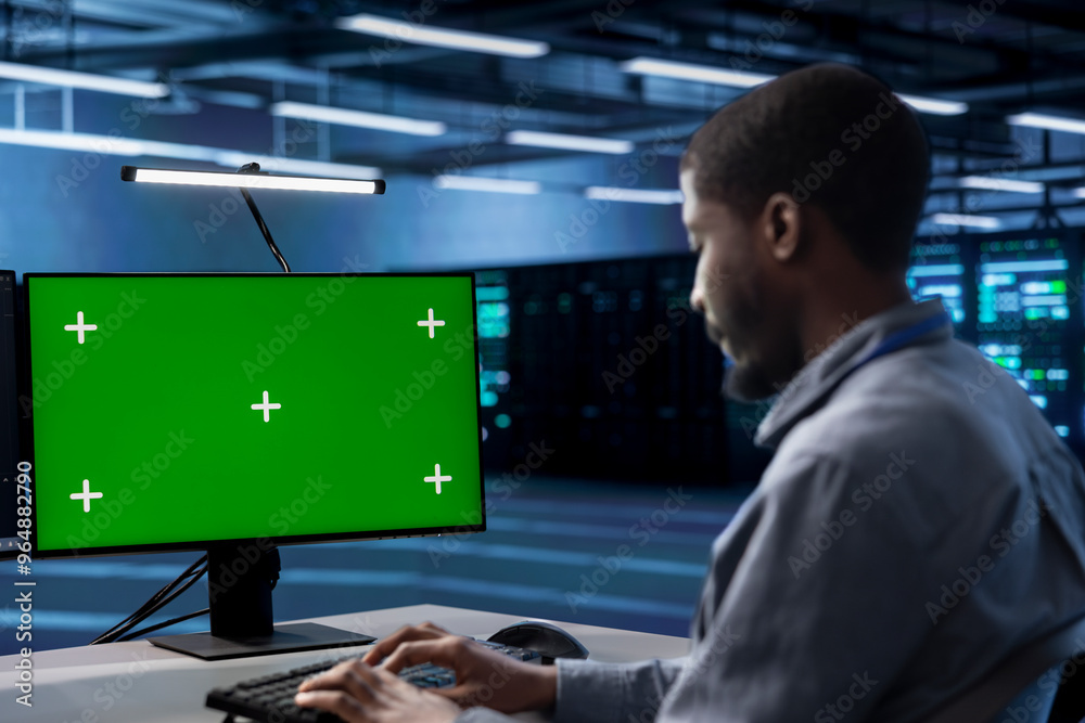Technician in server hub ensuring data remains shielded from potential threats using green screen PC. Employee safeguarding data center hardware against malicious access with mockup computer display Technician in server hub ensuring data remains shielded from potential threats using green screen PC. Employee safeguarding data center hardware against malicious access with mockup computer display