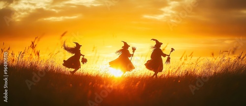 Three young witches running through grass at sunset silhouette