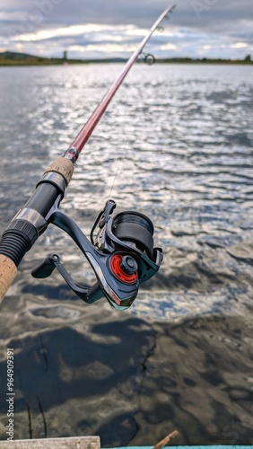 Obraz na płótnie Hand holding fishing rod and reel, fishing at Corrib river at Galway, Ireland, spinning, angling, catch and release, sport and leisure, nature background w salonie