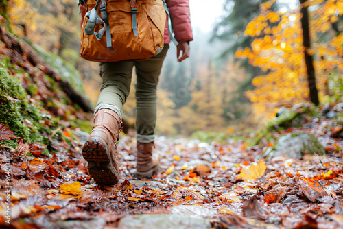 A person is walking through a forest with a backpack on