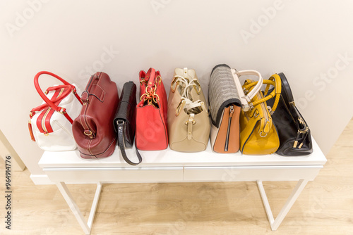 Collection of fashinable bags standing on a shelf in a row photo