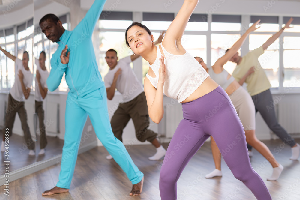 Obraz premium Active young Asian woman practicing hip-hop dance in training hall during dancing classes