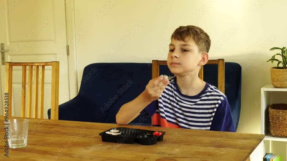 Boy eats sushi delivery at home using hands
Boy eats sushi delivery at home using hands