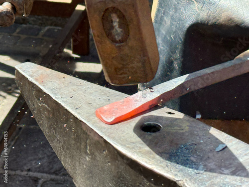 Blacksmith hammering hot metal on anvil, crafting iron, steel, forge, heavy metalwork, traditional craftsmanship, smithing process, handwork, metal shaping, blacksmith concept photo