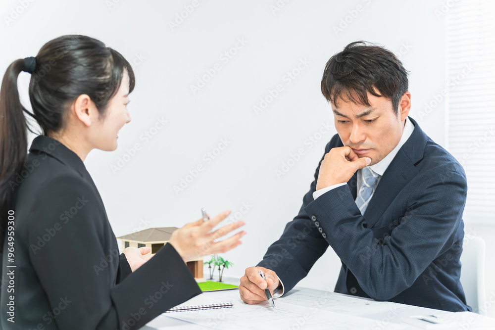 会議・ミーティングをする不動産業者のビジネスマン男女
