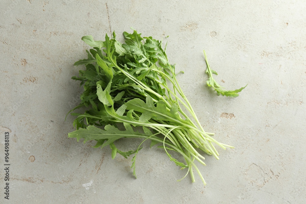 Many fresh arugula leaves on grey textured table, top view Many fresh arugula leaves on grey textured table, top view