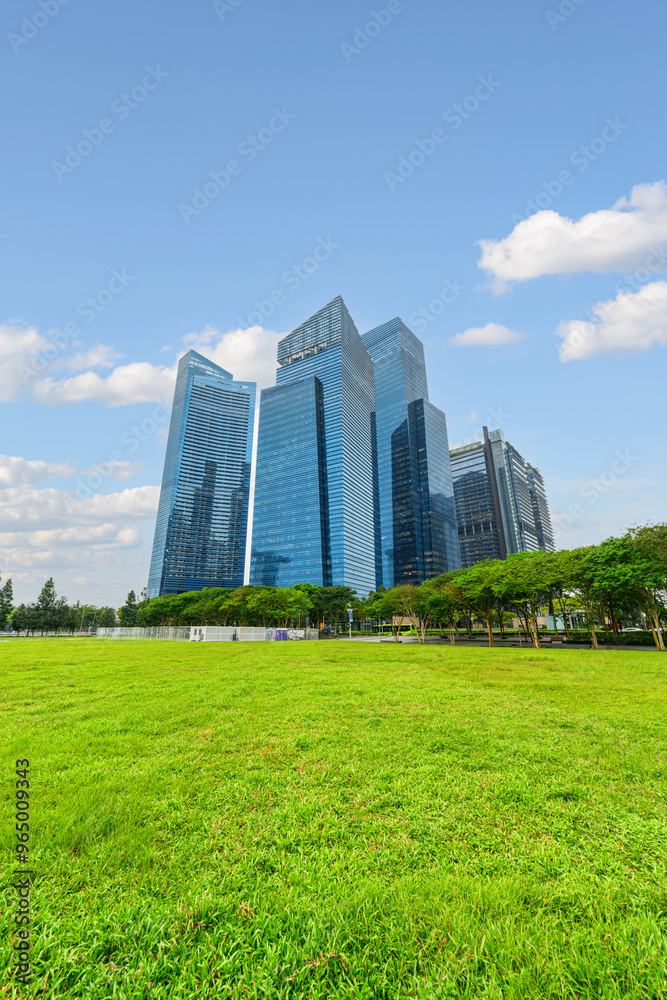 View of skyscrapers at downtown across green lawn in Singapore View of skyscrapers at downtown across green lawn in Singapore