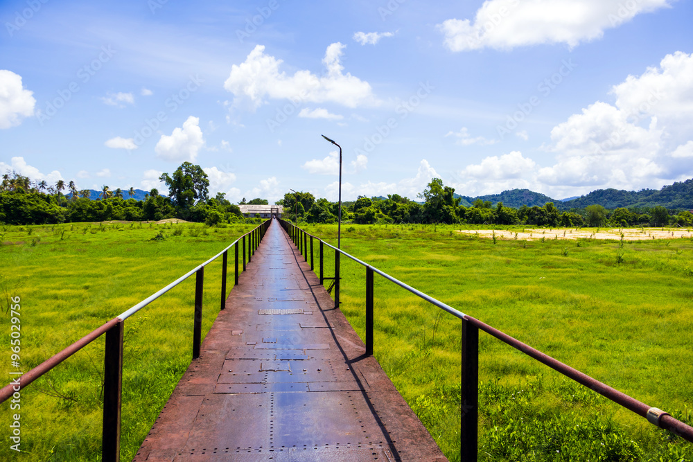 Boon Soong Iron Bridge with green glass field in Phang-nga Thailand in summer Boon Soong Iron Bridge with green glass field in Phang-nga Thailand in summer