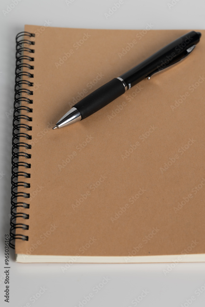 Notebook with a blank cover made of recycled paper with a black pen. Notebook with a blank cover made of recycled paper with a black pen.