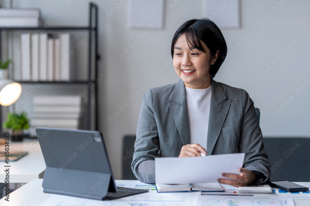 Asian businesswoman smiling and having video call on tablet in office Asian businesswoman smiling and having video call on tablet in office