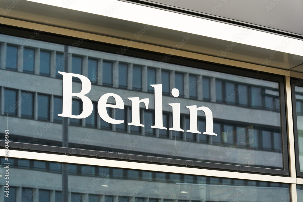Schriftzug Berlin an einem Schaufenster der deutschen Hauptstadt mit der Spiegelung eines Hauses Schriftzug Berlin an einem Schaufenster der deutschen Hauptstadt mit der Spiegelung eines Hauses