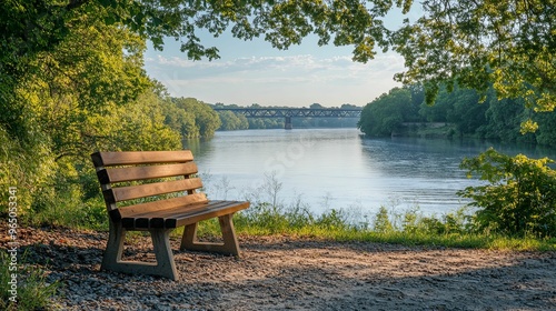 A Wooden Bench Overlooking a River and a Bridge in the Distance