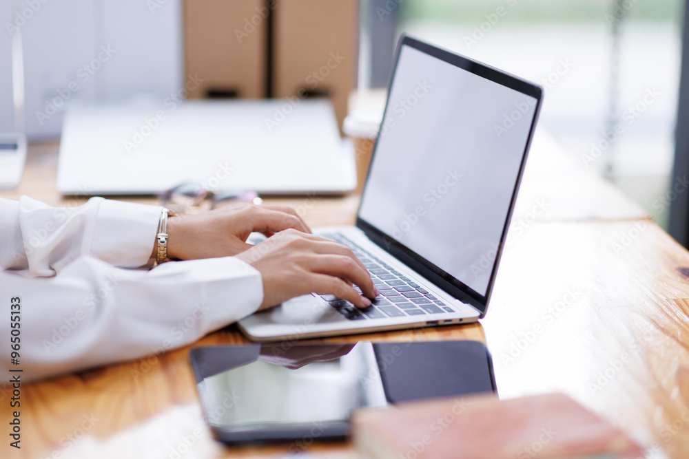 Business asian woman or female worker using a laptop computer to analyse her financial data.business people research or financial strategy in company concept. Laptop white screen mockup. Business asian woman or female worker using a laptop computer to analyse her financial data.business people research or financial strategy in company concept. Laptop white screen mockup.