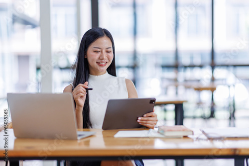 Business asian woman or female worker using a laptop computer to analyse her financial data.business people research or financial strategy in company concept. Laptop white screen mockup.