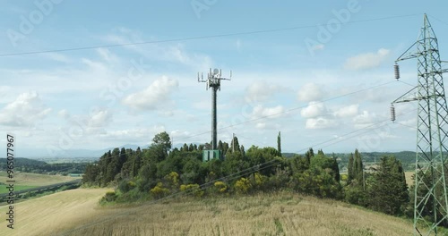 Telecom Antenna Tower And Electrical Pylon Tower On Hill In Italy. drone shot